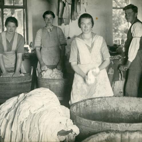 Gammelt fotografi af en gruppe kvinder, der vasker tøj